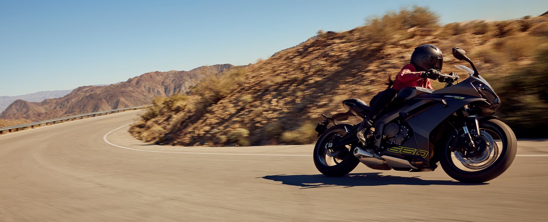 Triumph Daytona 660 in Satin Granite and Satin Jet Black riding on mountain road