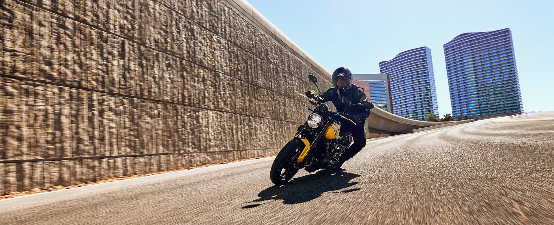 Triumph Trident 660 in cosmic yellow and sapphire black in urban setting cornering