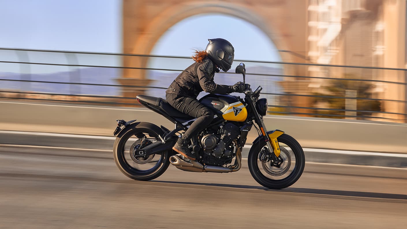 Triumph Trident 660 in urban setting riding by an arch