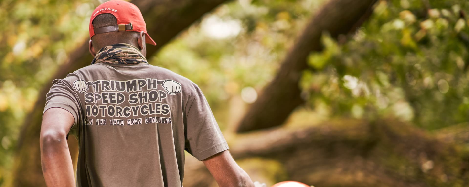 A Triumph Model wearing a Head Down Tee and Forecourt Cap in a forest)